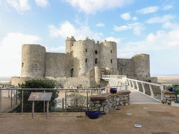 A historic stone castle with a bridge leading to the entrance.
