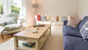 A living room with a sofa, armchair, coffee table, and a lamp. - 4 Llain yr Eglwys (Newport)