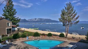 A swimming pool with lounge chairs, a beach, and a mountain view. - Llc1236 - Lakeside Landing 4 Bedroom Condo (South Lake Tahoe)