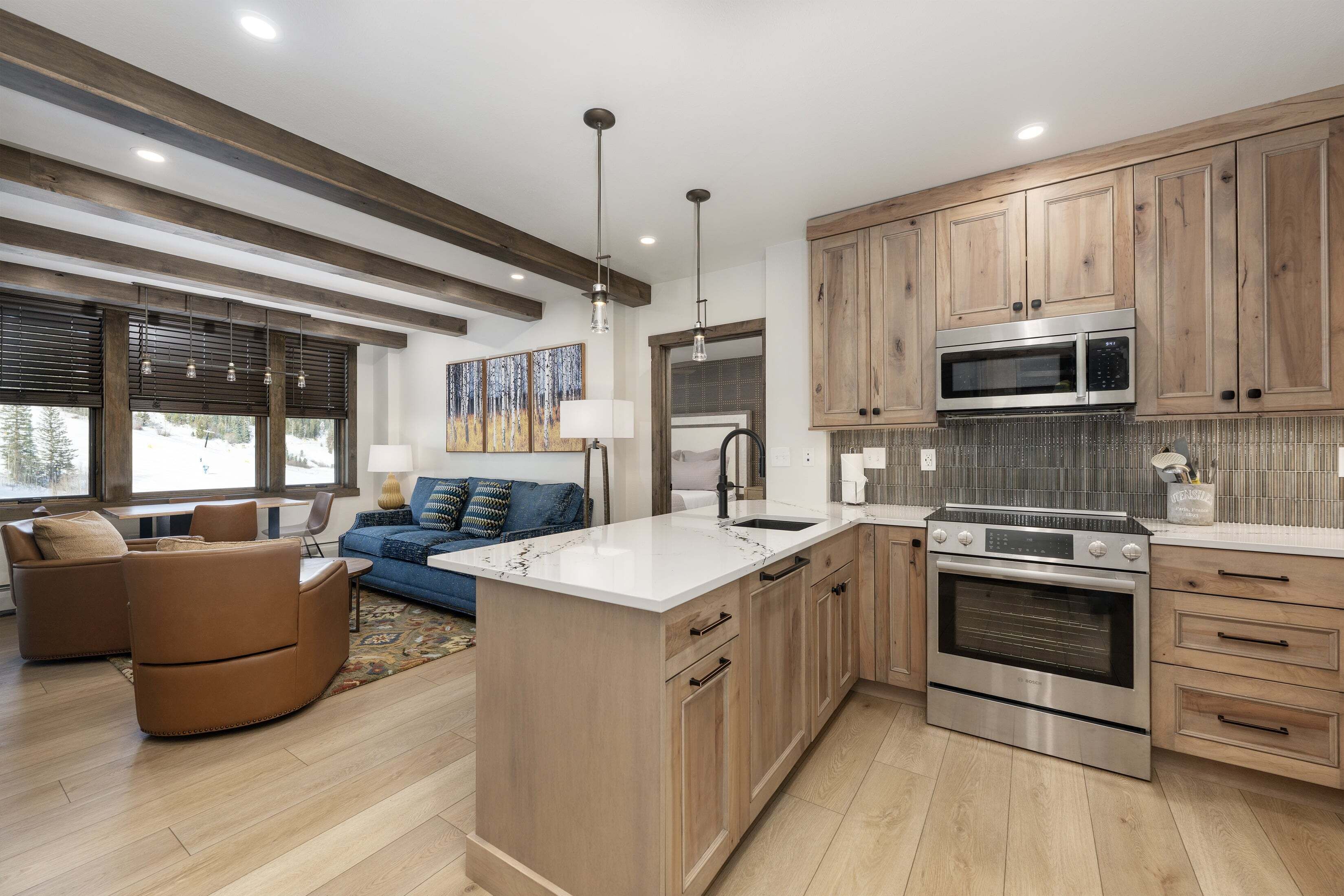 A modern kitchen with wooden cabinets, stainless steel appliances, and a central island.