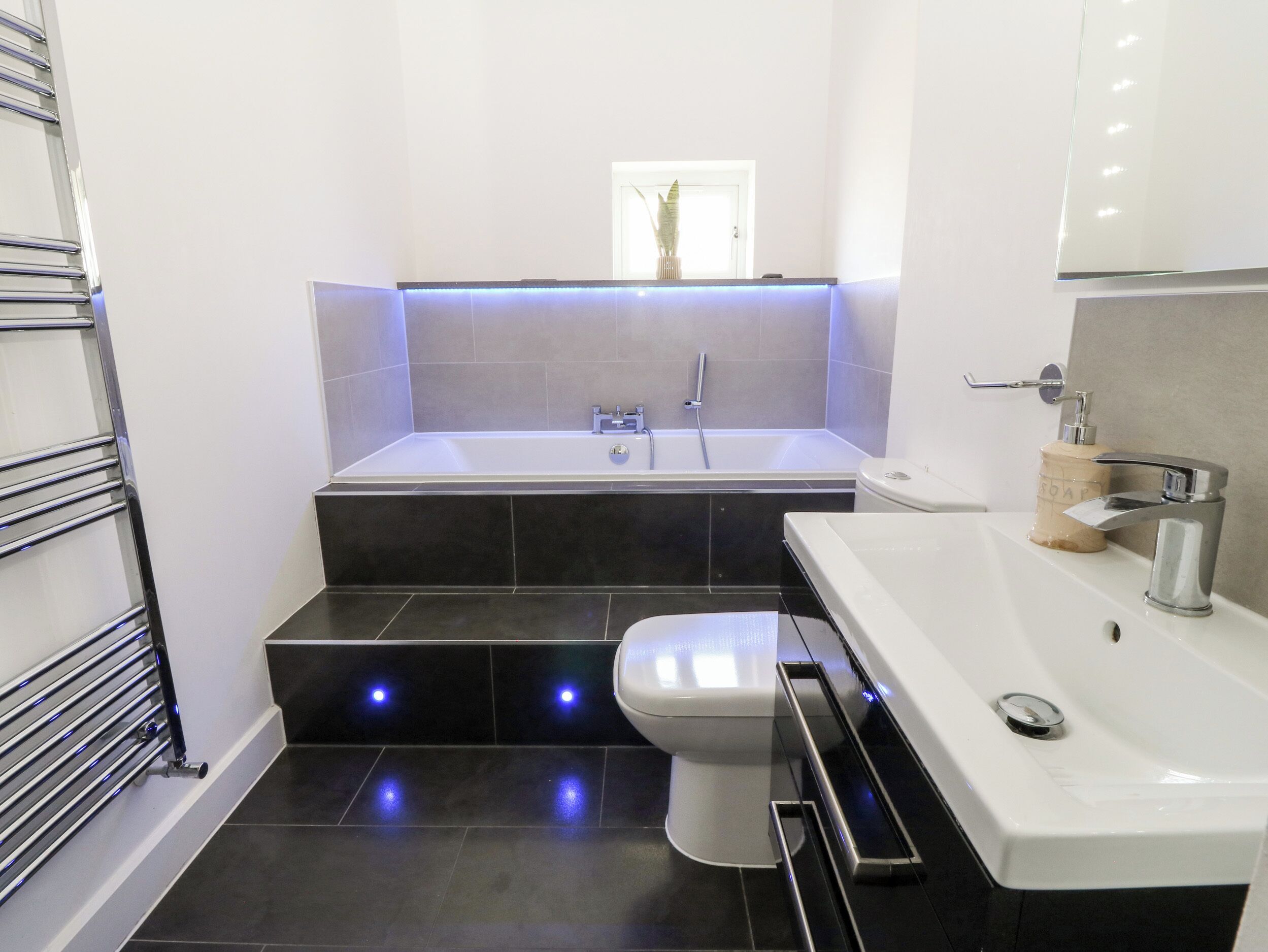 A modern bathroom with a bathtub, toilet, and sink.