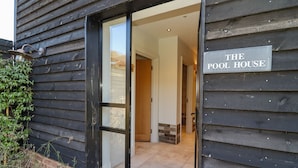A wooden building with a sign reading "THE POOL HOUSE". - The Stables (Ledbury)