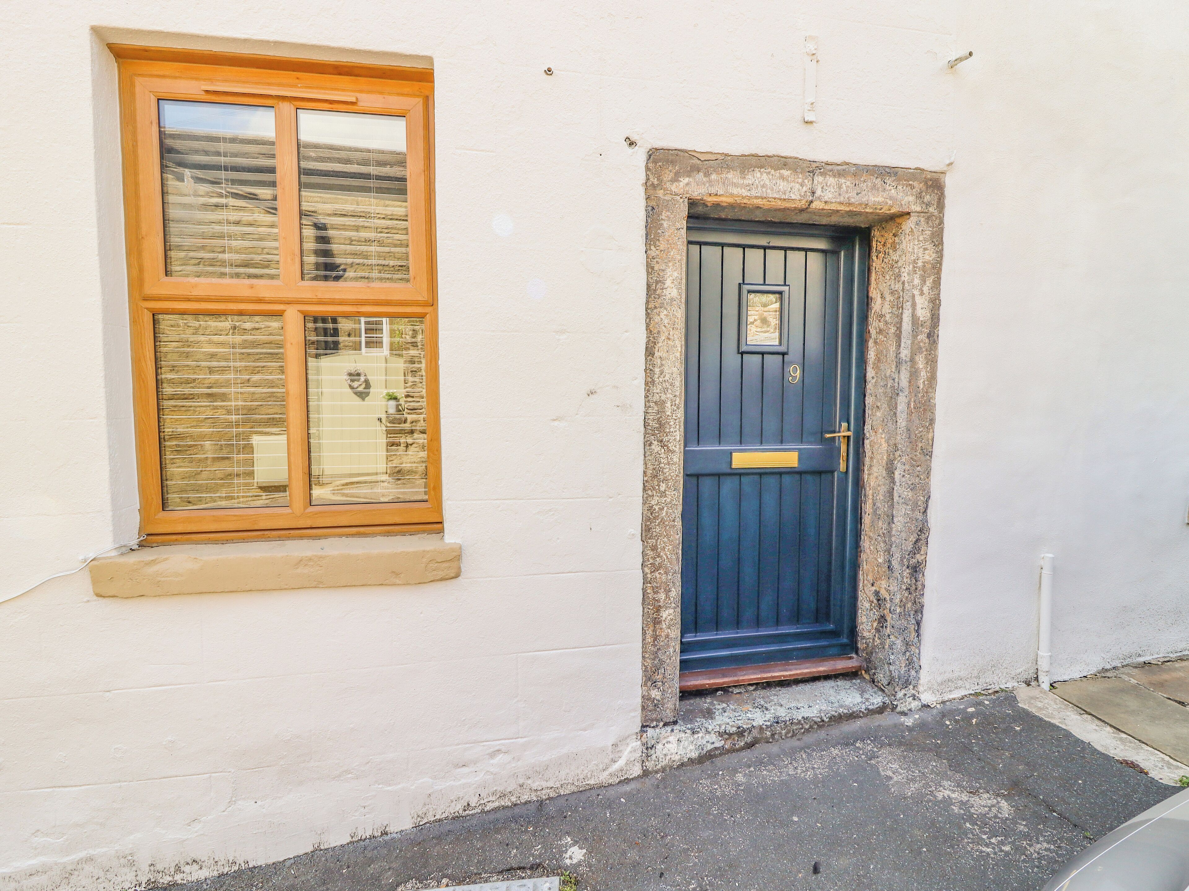 Un edificio blanco con una puerta azul y una ventana con marcos de madera.