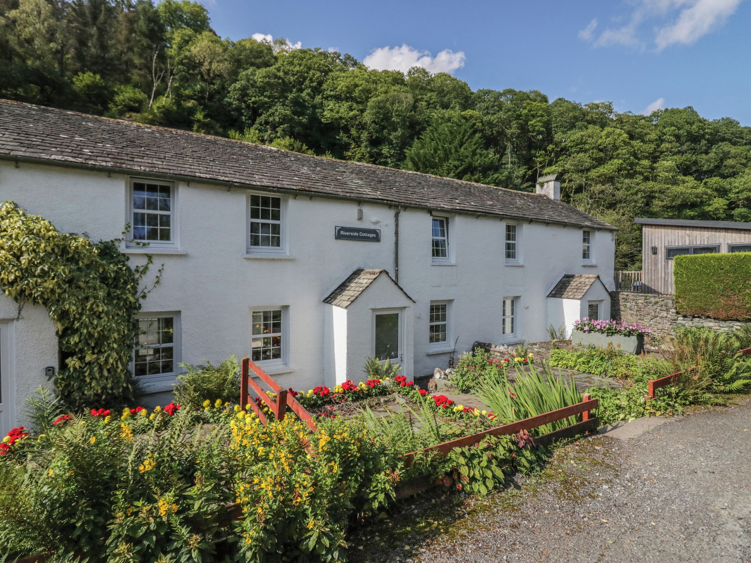 A white building with a sign reading "Riverside Cottages".