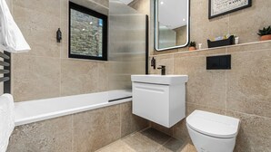 Un baño moderno con bañera, inodoro y lavamanos.