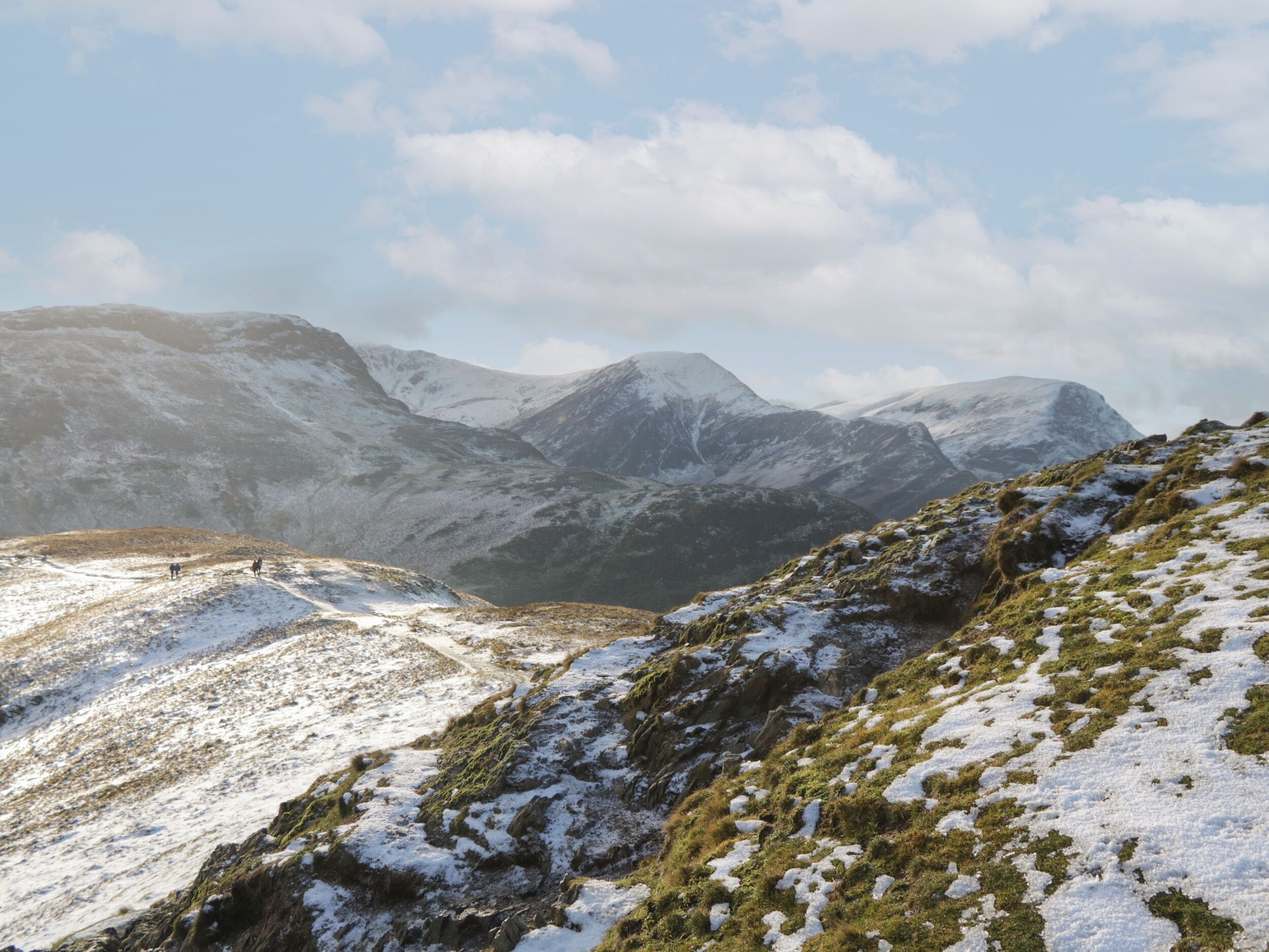 A mountainous landscape with snow-covered slopes and a clear sky.