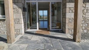 A stone building with a glass entrance leading to a balcony.