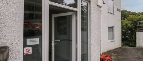 A building with a sign reading "Apartments 1-6" and a glass door entrance.