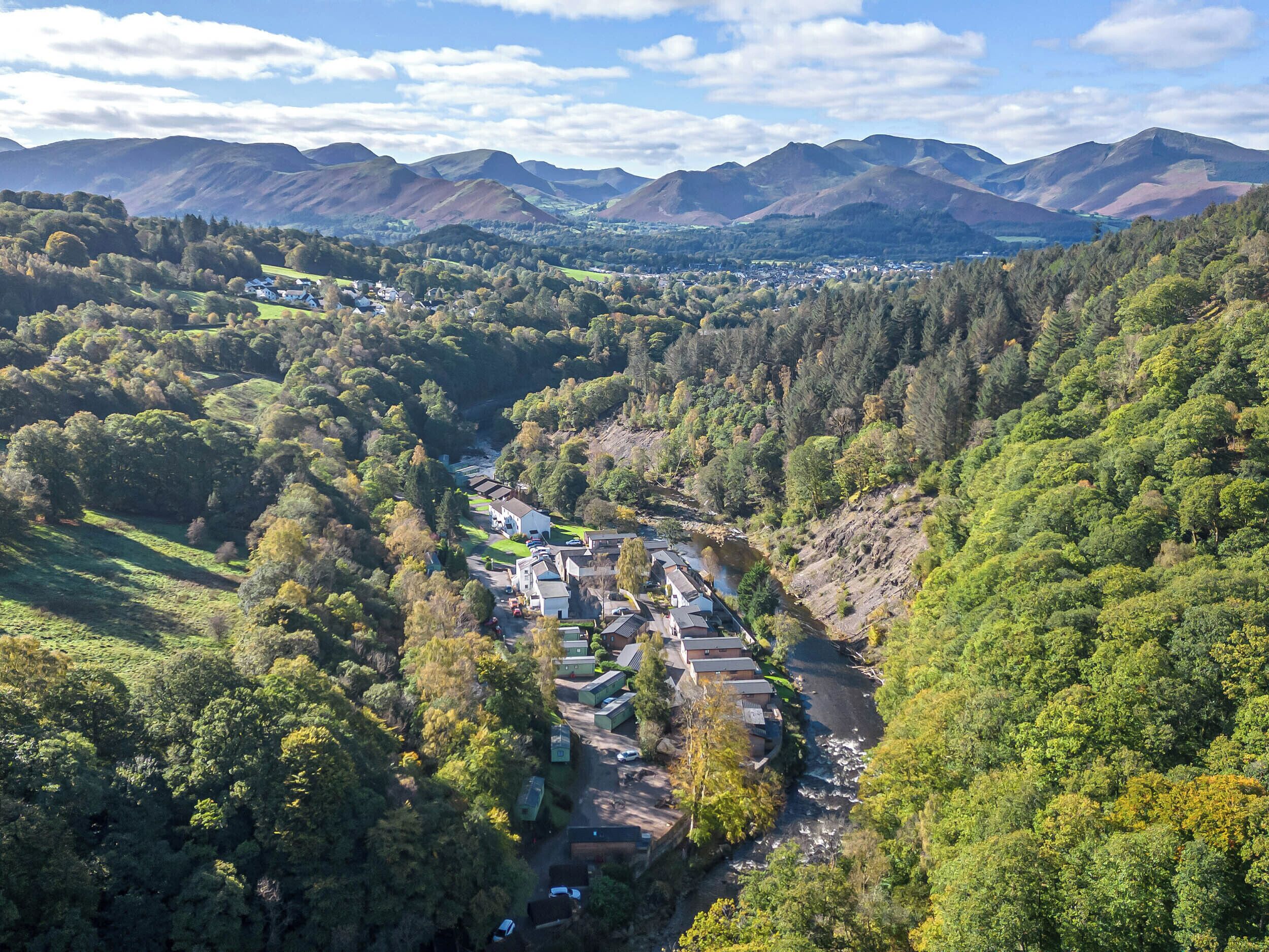 A valley with a small settlement surrounded by mountains.