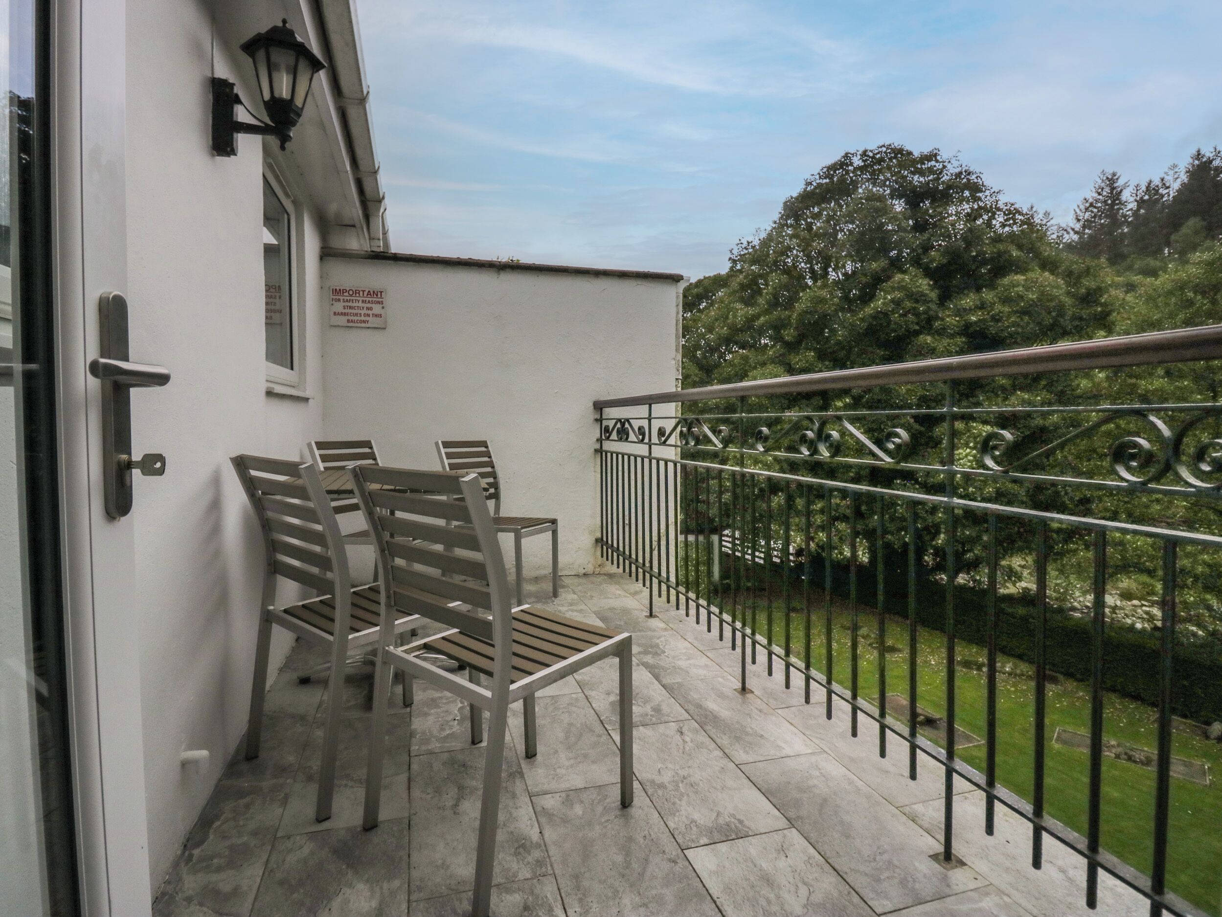 A balcony with metal chairs and a metal railing.