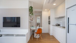 A modern kitchen with white cabinetry, a built-in oven, and a refrigerator. - Extension Berrini (Sao Paulo)