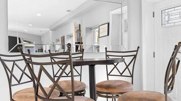 Un coin repas avec une table ronde et quatre chaises dotées de sièges rembourrés.