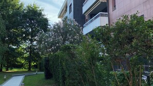 A modern multi-story building with balconies, surrounded by lush greenery and a clear sky. - Trilo Rho Fiera Milano House Rino Palmanova 12 (Rho)