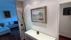 A modern living room with a white desk, a framed landscape painting, and a sofa. - Trilo Rho Fiera Milano House Rino Palmanova 12 (Rho)