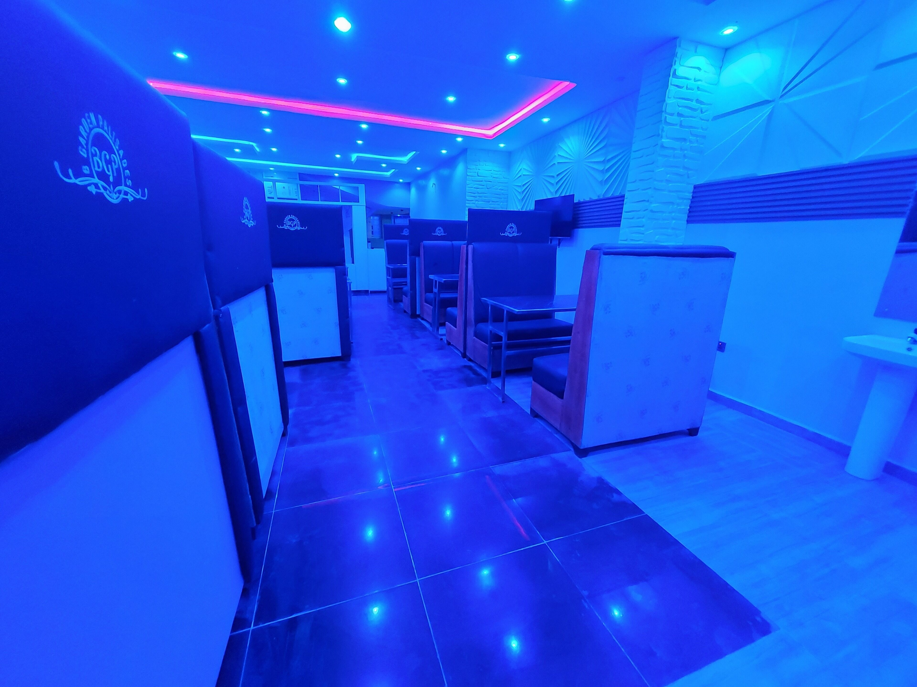 A room with a tiled floor, a reception desk, and seating areas.
