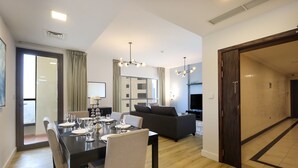 Ein modernes Hotelzimmer mit Essbereich, Wohnbereich und einem großen Fenster.