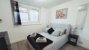 A bedroom with a bed, a nightstand, a dresser, a window, and a painting on the wall. - 1 Bed-park View-balcony-wifi-pet Friendly (London)