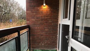 A balcony with a brick wall, a metal railing, and a door with glass panels. - 1 Bed-park View-balcony-wifi-pet Friendly (London)
