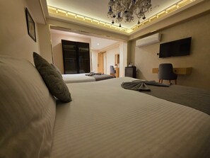 A hotel room with a large bed, a television, and a chandelier. - Dyafa Pyramids Hotel & Spa (Giza)