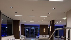 A spacious lobby with a polished marble floor, a staircase with a metal railing, and a seating area with sofas and cushions. - Dyafa Pyramids Hotel & Spa (Giza)