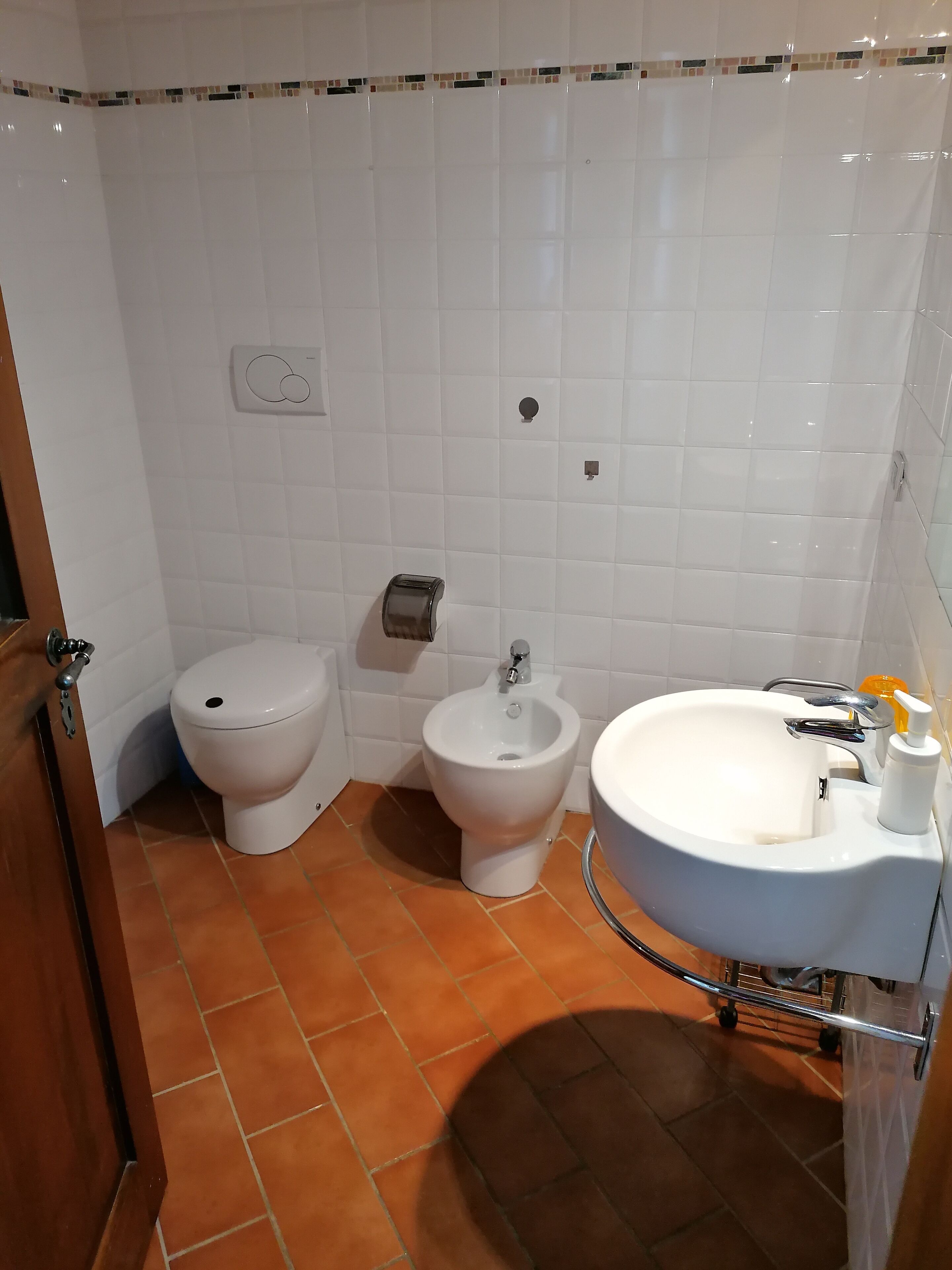 A bathroom with a toilet, bidet, and sink.