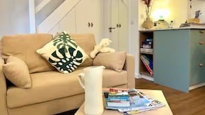 A living room with a beige sofa, a white pitcher, and a magazine on a coffee table. - Studio 3 persons 50m from Grande Plage Surf (Biarritz)