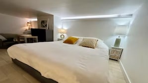 A bedroom with a large bed, a desk, and a chair. - Studio 3 persons 50m from Grande Plage Surf (Biarritz)