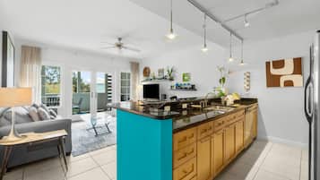 Una cocina moderna con una isla central, armarios de madera e iluminación colgante.