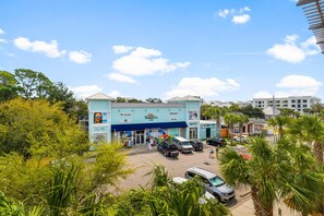 A beachfront building with multiple storefronts, including a beach outfitters and a restaurant. - Cassine Station by Panhandle Getaways (Santa Rosa Beach)