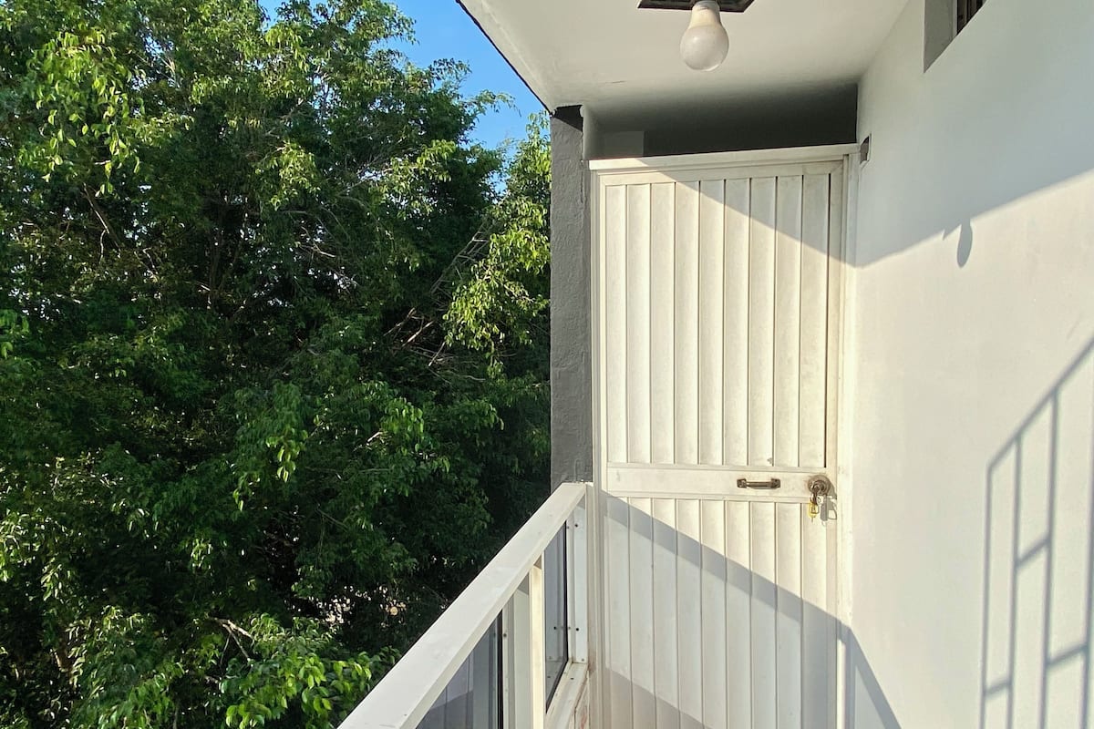 A white door with a keyhole, a small window, and a light fixture above it.