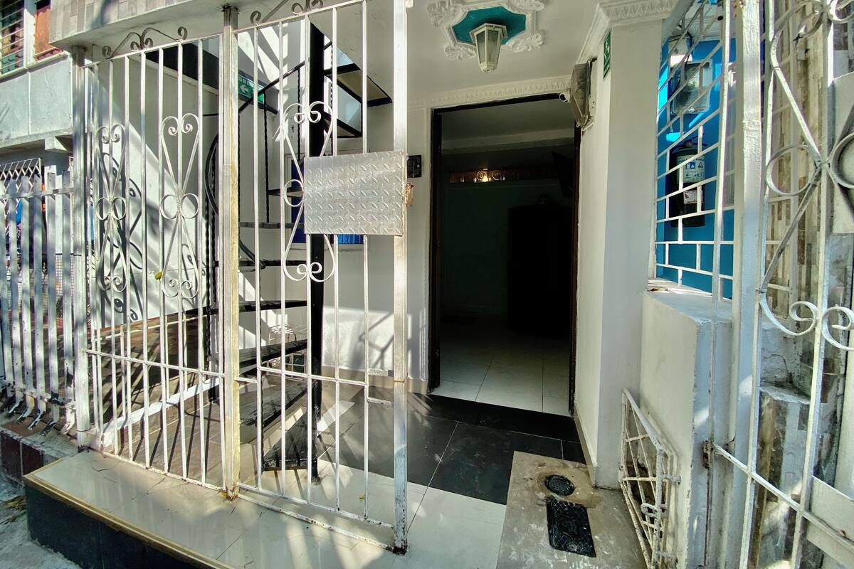 A gated entrance with a metal gate and a small sign.