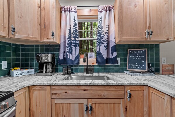 A kitchen with wooden cabinets, a coffee bar, and a sign indicating a retreat center.