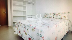 Una camera da letto con un letto, un'ampia armadio bianca e un condizionatore d'aria.