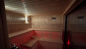 Eine Sauna mit Holzbänken und roter Beleuchtung.
