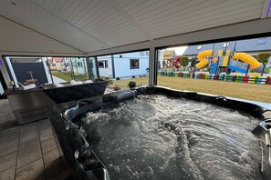 Ein Whirlpool mit Blick auf einen Spielplatz und ein Haus.