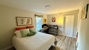 Une chambre à coucher avec un lit, un bureau et un ordinateur.