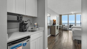 Una cocina moderna con armarios blancos, lavavajillas integrado y vistas al balcón.