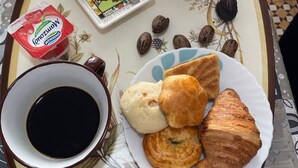 A tray with a bowl of cereal, a croissant, a muffin, and a cup of coffee. - Vacation room (El Biar)