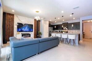 Relax in a spacious living area with a large sofa and flat-screen TV, or cook in the well-equipped kitchen with central island and bar stools.
