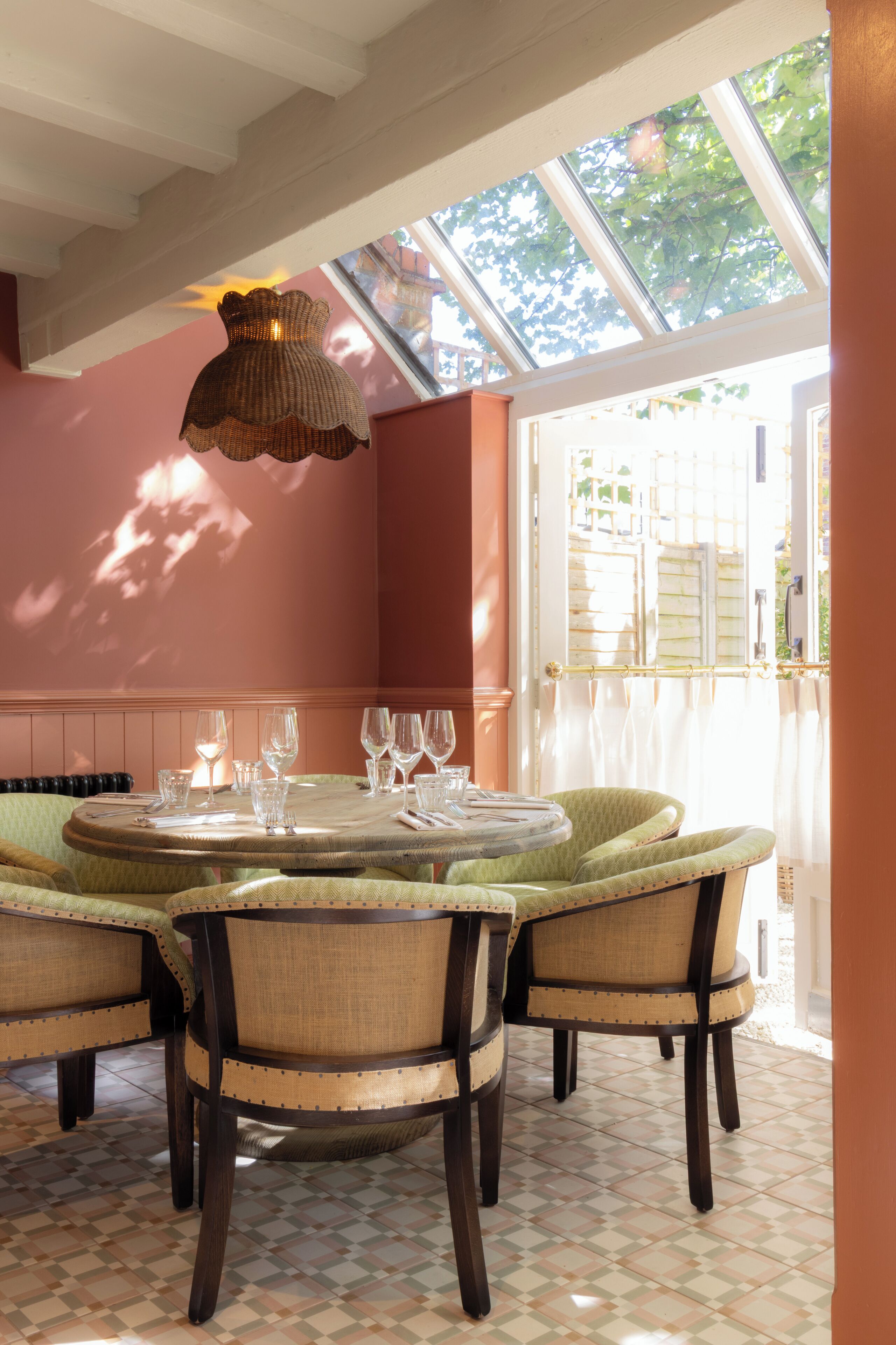 Uma sala de jantar com uma mesa redonda, quatro cadeiras e um lustre.