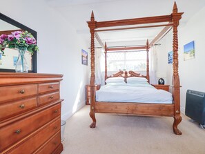 A four-poster canopy bed with a wooden frame and a single bed runner. - 1 Atlantic View (Newquay)