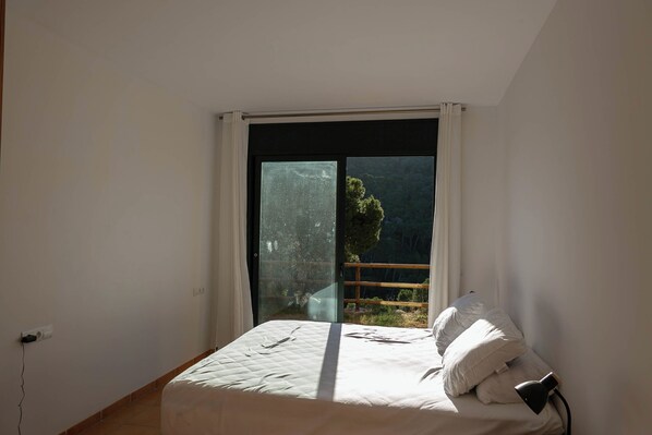 A bedroom with a large window, a bed with pillows, and a bedside table. - Semi-detached w/ views in Sa Tuna, Begur (H05) (Begur)