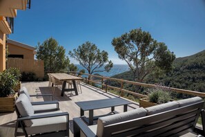 An outdoor deck with seating and a table, overlooking a mountainous landscape and the sea. - Semi-detached w/ views in Sa Tuna, Begur (H05) (Begur)