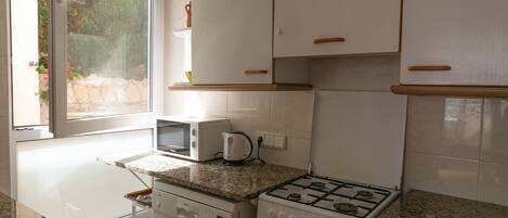 A kitchen with white cabinets, a microwave, a stove, and a dishwasher.