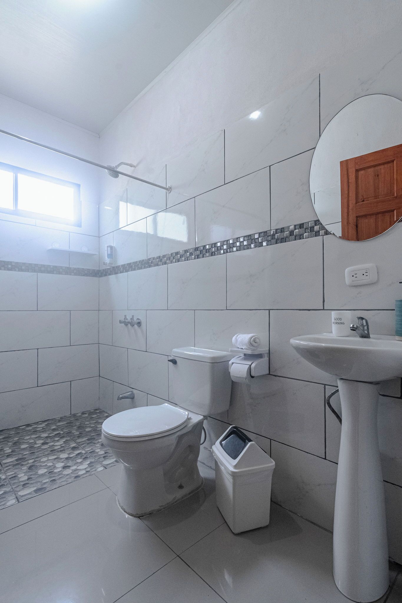 Un baño con inodoro, bidé, lavabo y espejo.