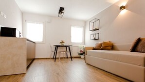 A modern apartment with a kitchen, dining area, and living room. - Colibri House (Sottomarina)
