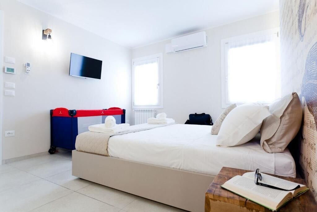 Quarto com cama, televisão, ar condicionado e janela.