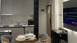 Eine moderne Küche mit grauen Schränken, einem eingebauten Ofen und einem Essbereich mit Tisch und Stühlen.