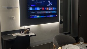 Ein modernes Wohnzimmer mit einem an der Wand befestigten Flachbildfernseher, der eine Speisekarte zeigt.