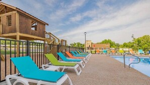 A poolside area with lounge chairs and a wooden building.